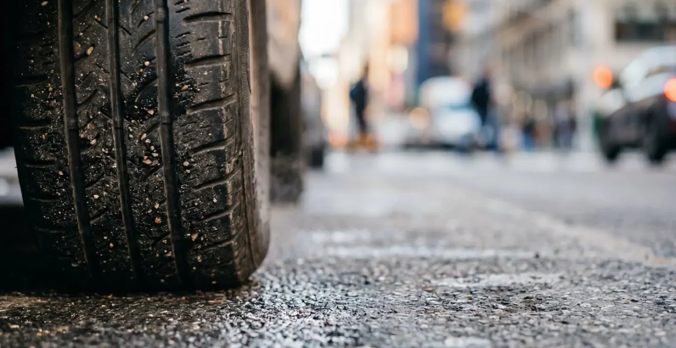Close-up view of delivery vehicle wheel and pavement showing the reality of urban idling