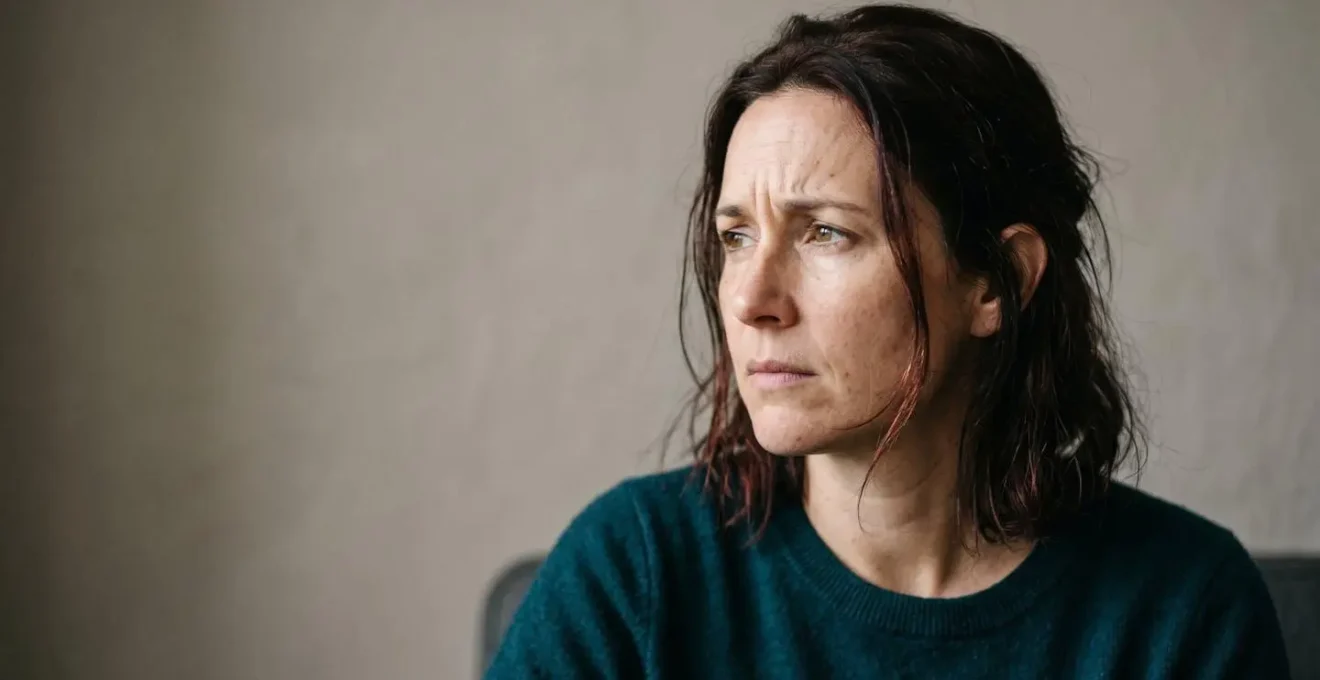A person looking at a screen with a concerned and anxious expression, representing the emotional impact of fake news.