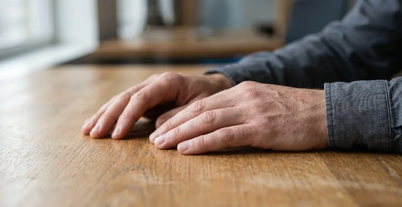 A person's hands resting mindfully on a minimalist office desk in a brief moment of workplace meditation