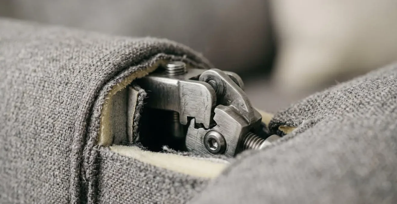 Close-up macro view of high-quality steel connector hardware joining modular sofa sections