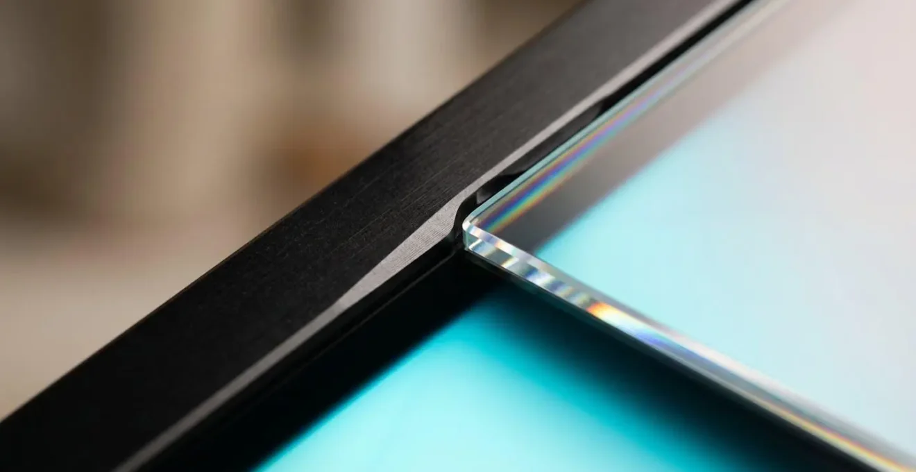 Extreme close-up macro detail of digital frame corner showing textural surface and ambient glow with no visible text or interface